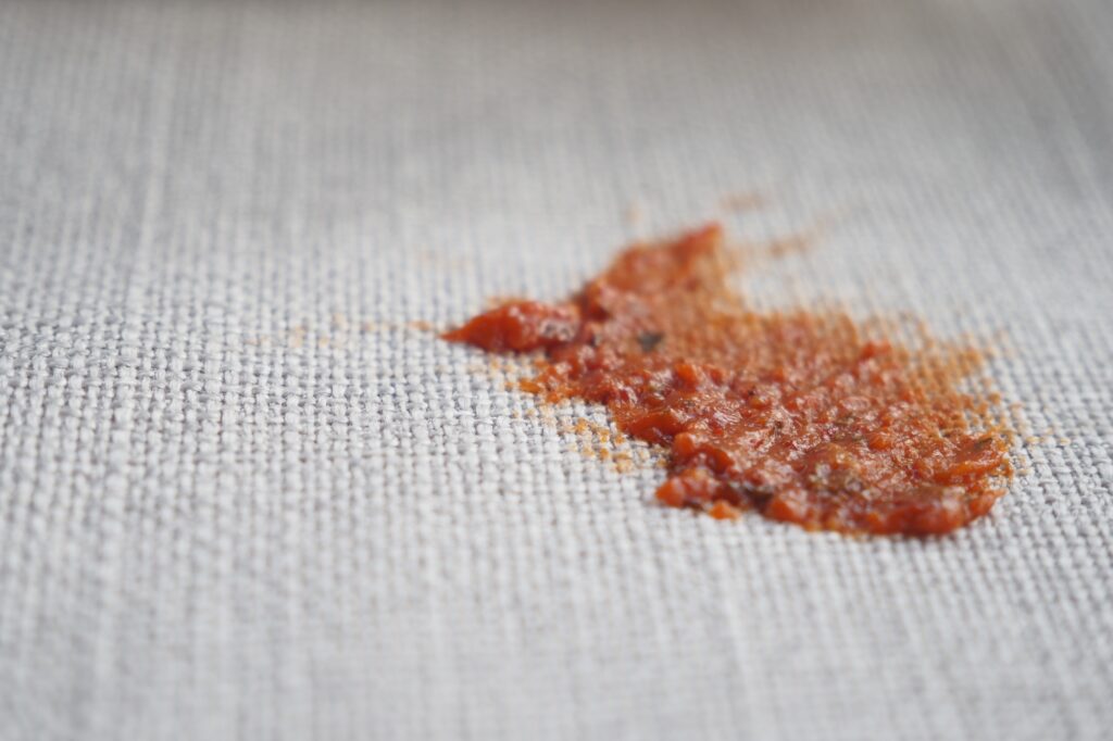 Stain on fabric from spilled tomato sauce at lunchtime