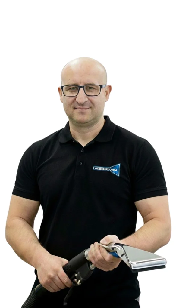Piotr Bojarski - właściciel w firmowej koszulce Turboszczotka trzymający ssawkę ekstrakcyjną - mobilne pranie dywanów i tapicerki w Gdańsku.